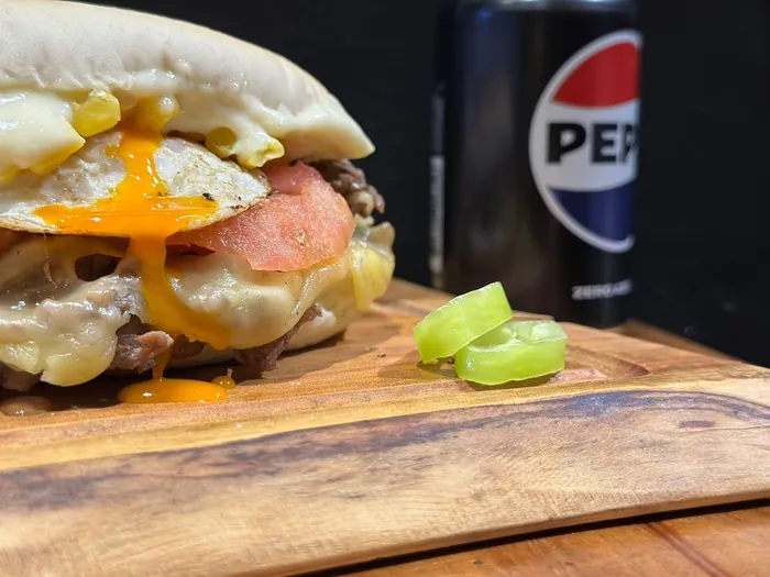 Sándwich con huevo frito, queso derretido y tomate