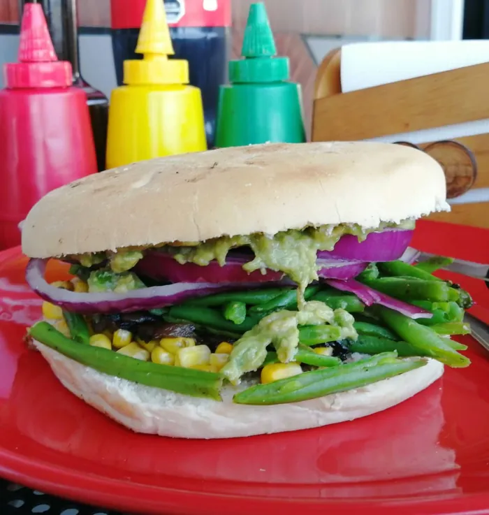 Sándwich vegetariano con porotos verdes, choclo, cebolla morada y palta